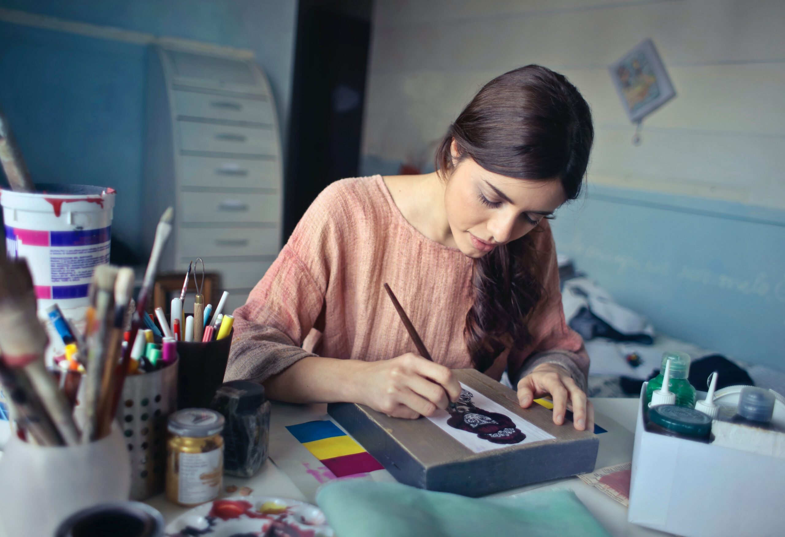 Female artist painting a picture at her desk